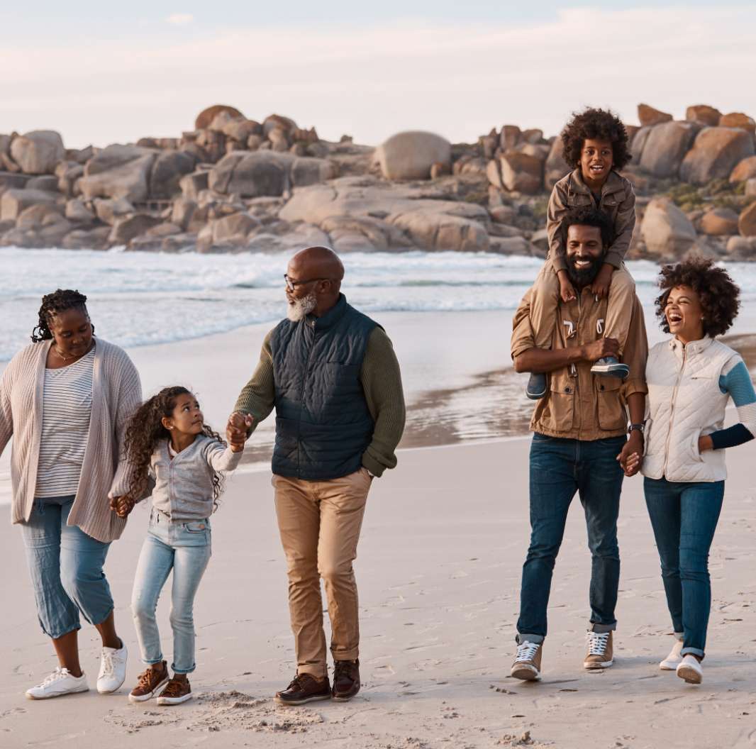 Black multi-generational family walking on the beach